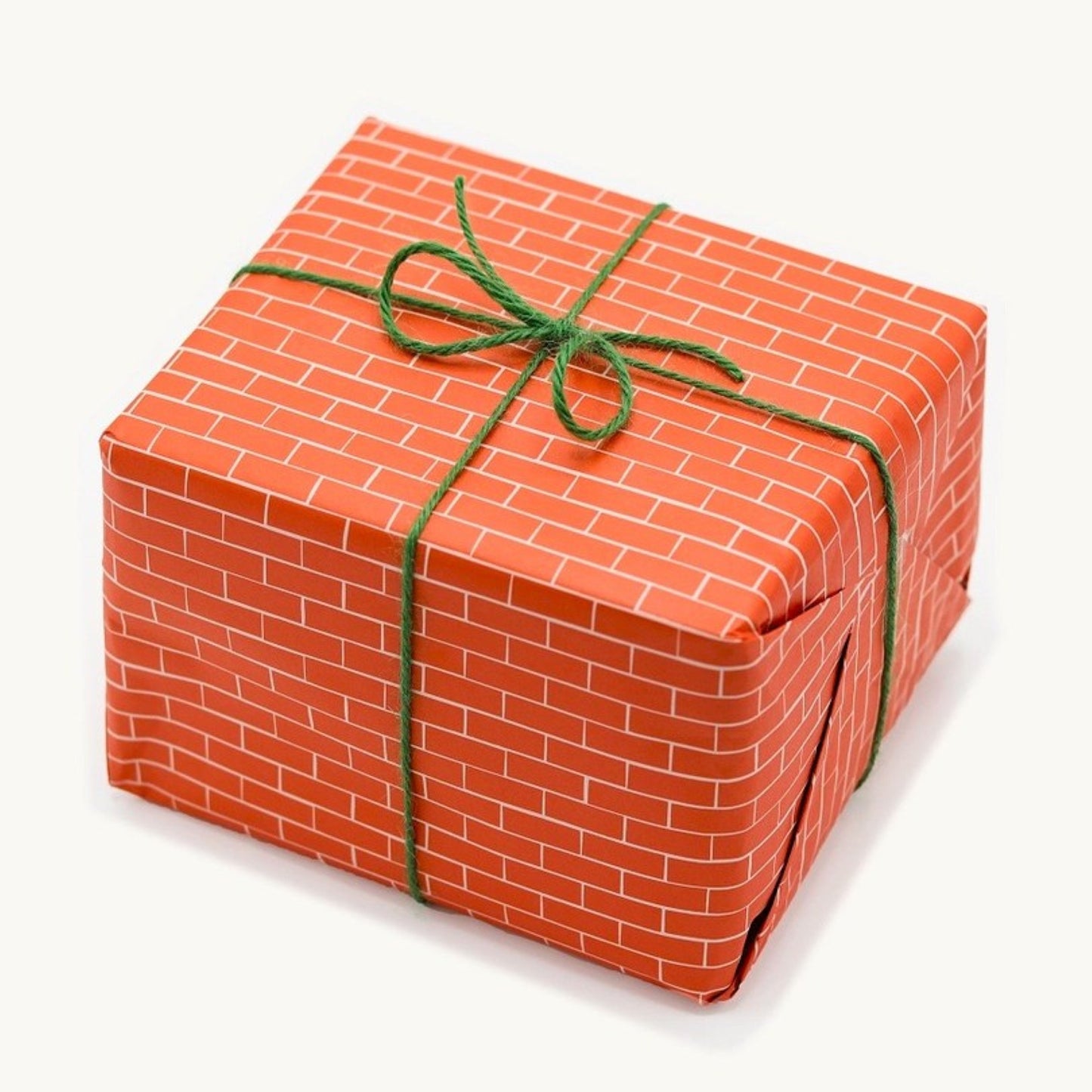 a sheet of gift wrap with a small brick design in rich red and pink
