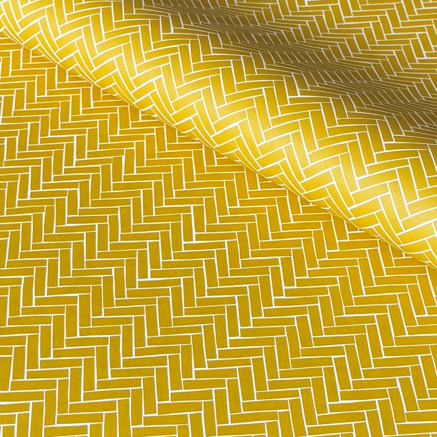 a sheet of wrapping paper with a parquet floor design in mustard and white