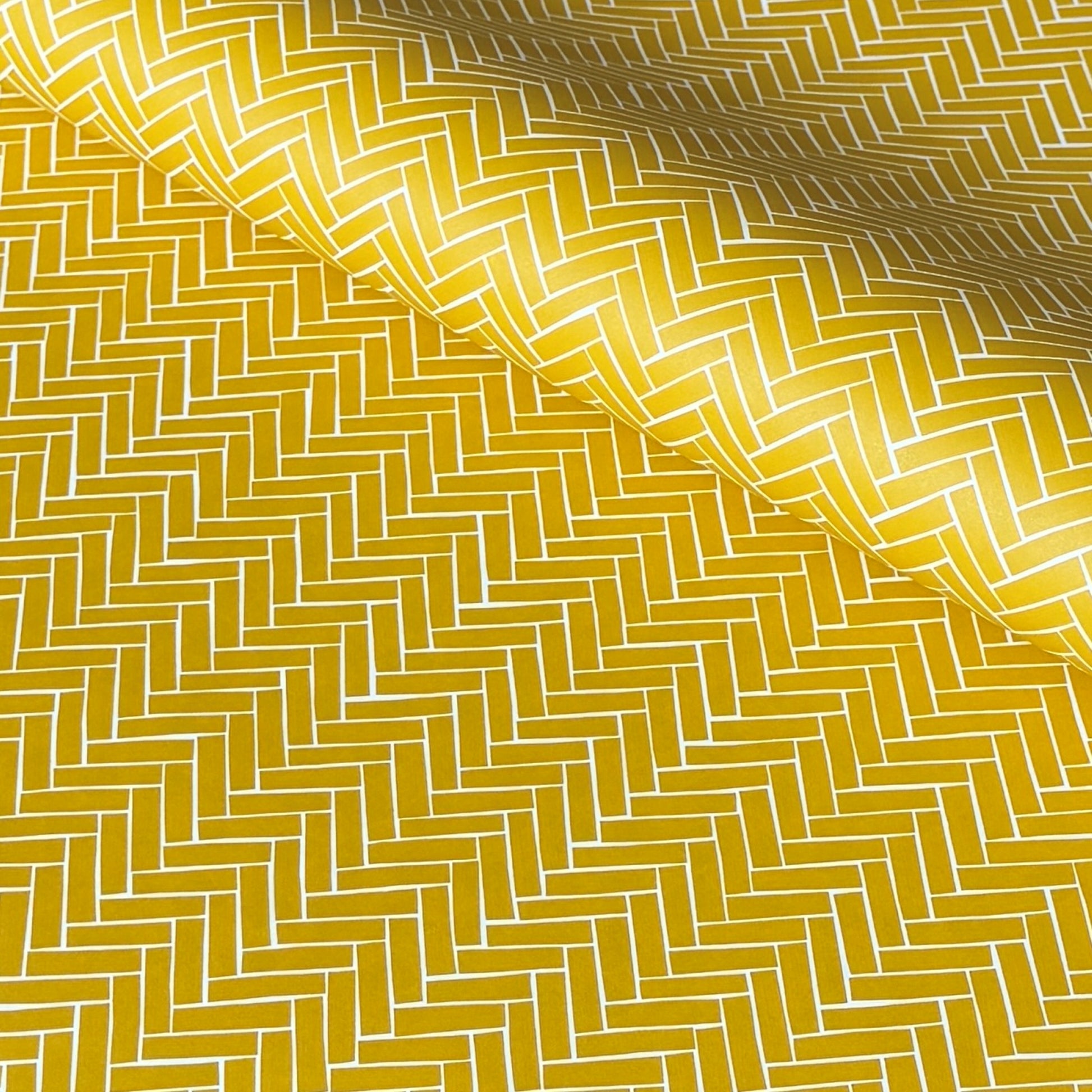 a sheet of wrapping paper with a parquet floor design in mustard and white