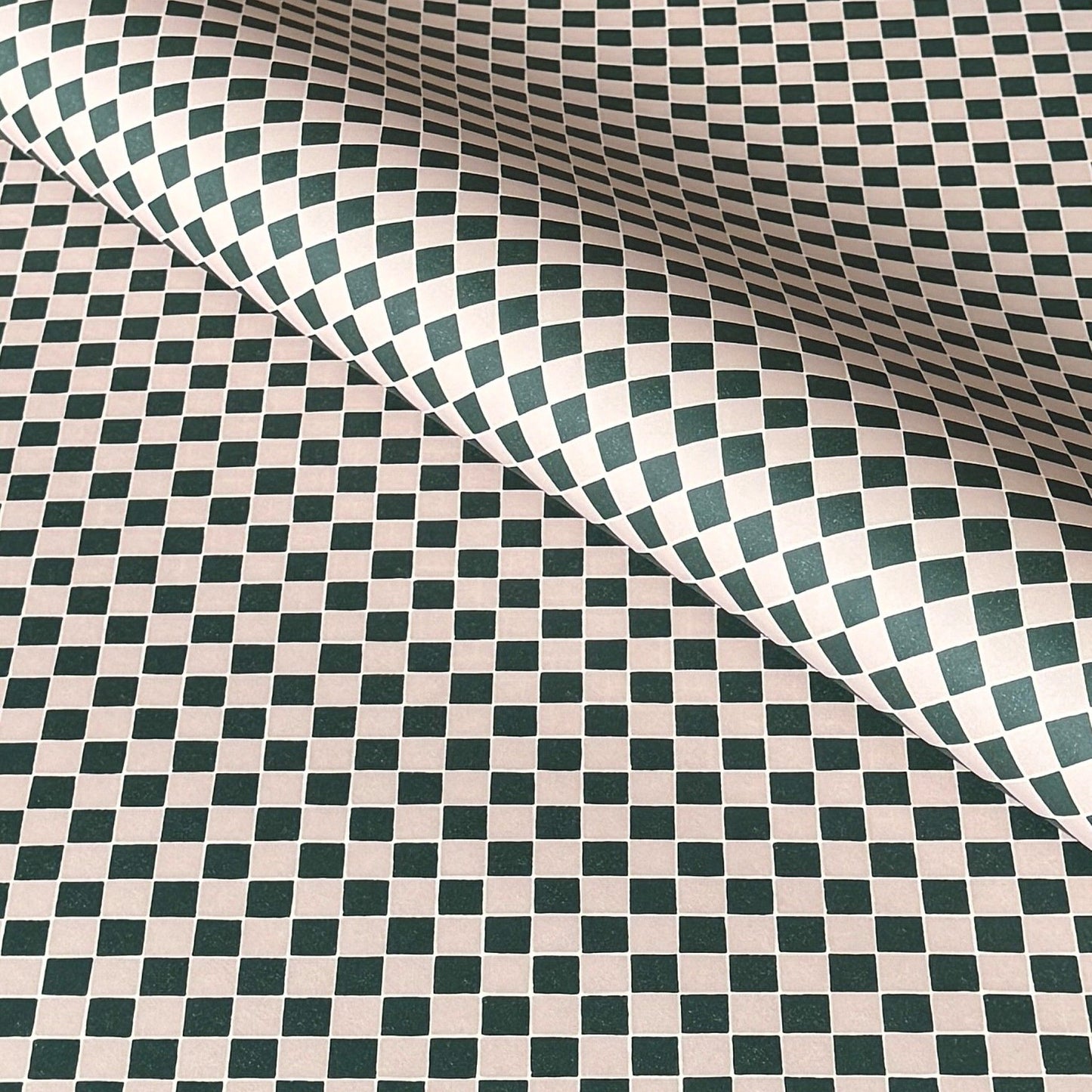 a sheet of wrapping paper with a quarry tile chequerboard design in very dark green and pale pink