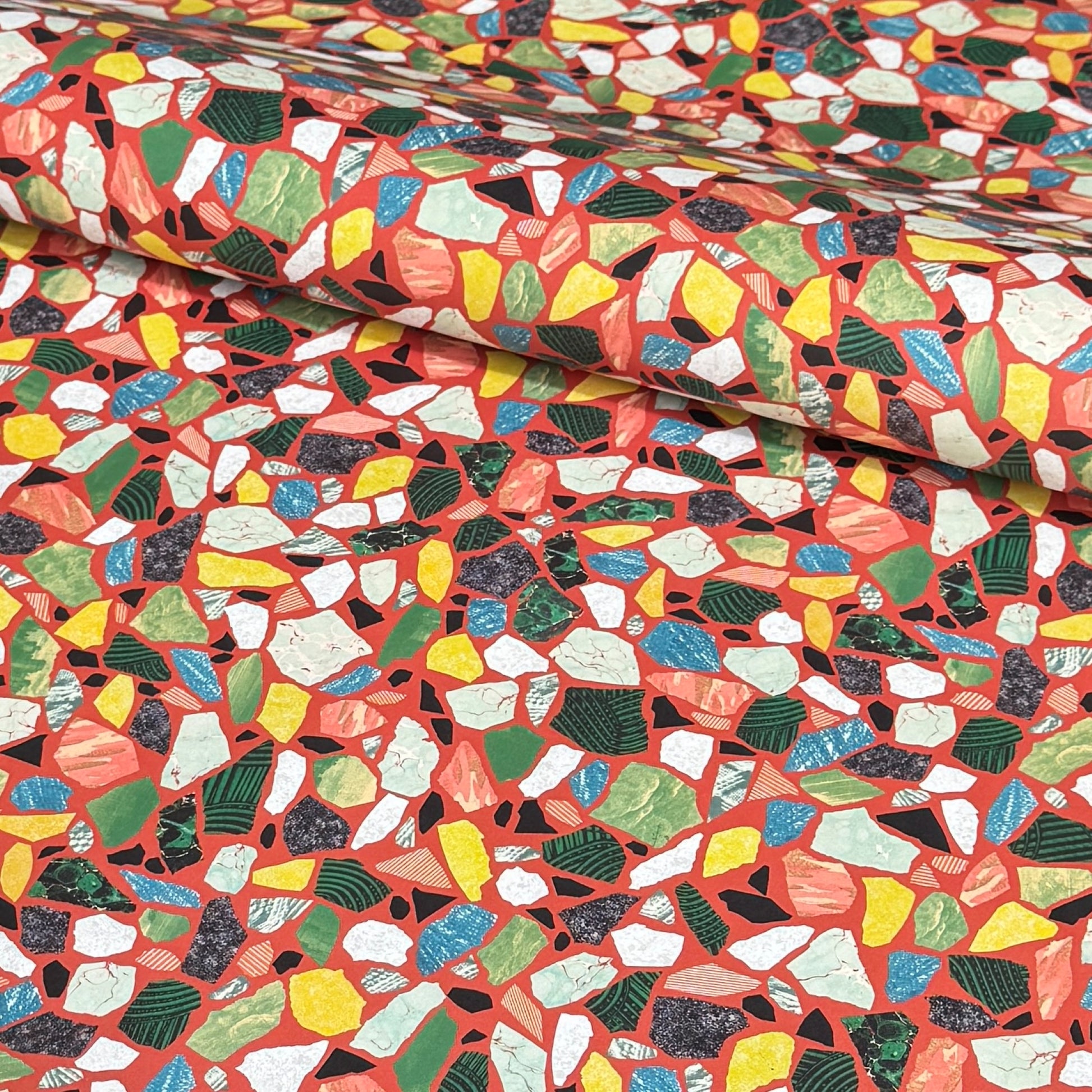 Colorful terrazzo pattern on a red background. A sheet of wrapping paper.