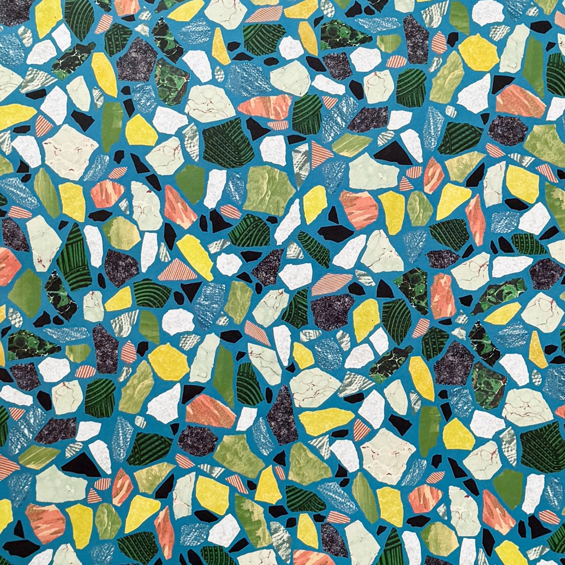 a sheet of wrapping paper with a teal blue background and terrazzo pattern