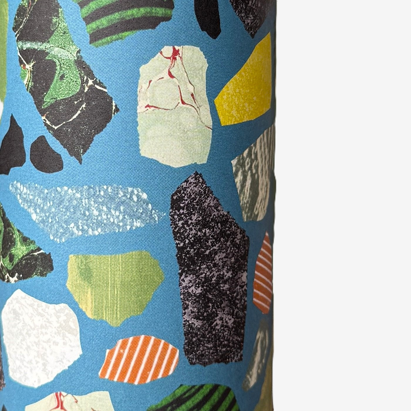 a sheet of wrapping paper with a teal blue background and terrazzo pattern