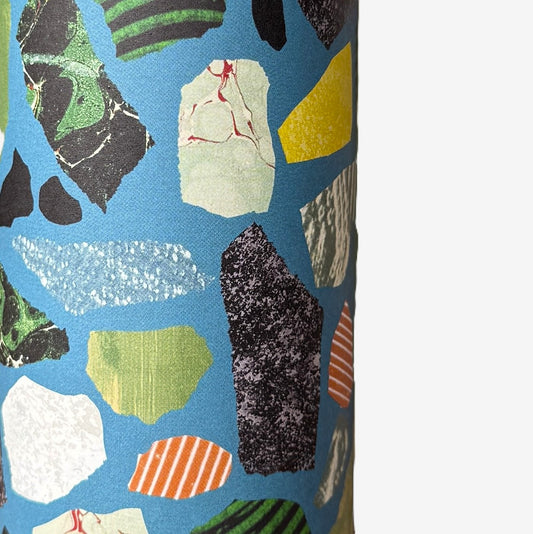 a sheet of wrapping paper with a teal blue background and terrazzo pattern