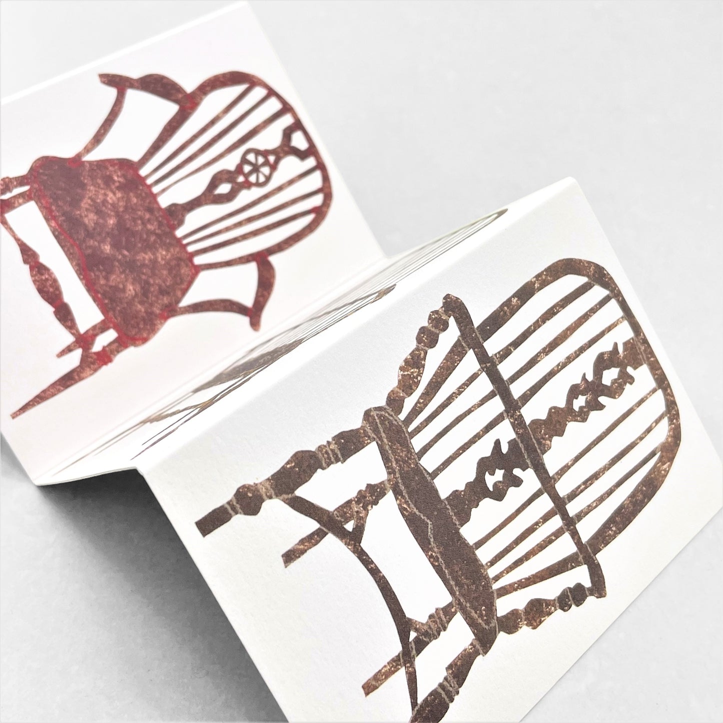 a concertina greeting card with four folds and drawings of four stick-back wooden chairs, by Hadley Paper Goods