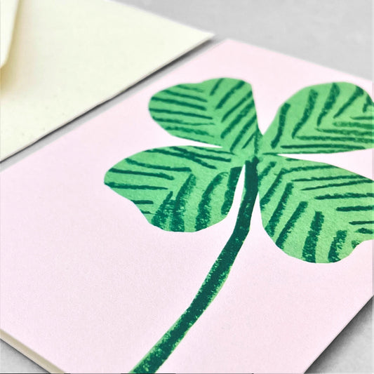 small greetings card with a green four leaf clover on pink background, by Hadley Paper Goods