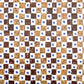A sheet of wrapping paper by Hadley Paper Goods with a chequerboard pattern of brown marbled squares on a white background with a blue dot.
