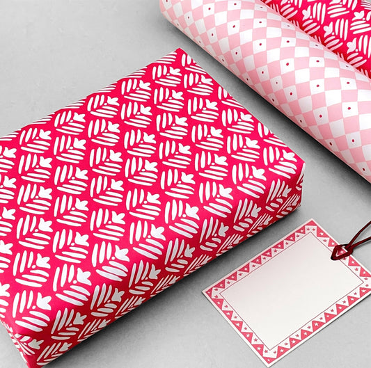 wrapping paper with magenta backdrop and a white flower repeat pattern by Heather Evelyn