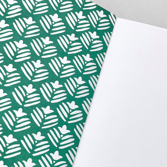 A5 notebook with dark green cover and a repeat pattern of white flowers by Heather Evelyn