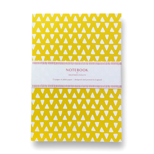 A5 notebook with bright yellow cover and repeat pattern of white triangles by Heather Evelyn