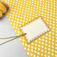 White rectangular gift tag with dark yellow star pattern border and yellow cord by Heather Evelyn