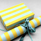 wide classic stripe wrapping paper in blue & yellow by Heather Evelyn. shown as a present with a roll of the patterned paper alongside