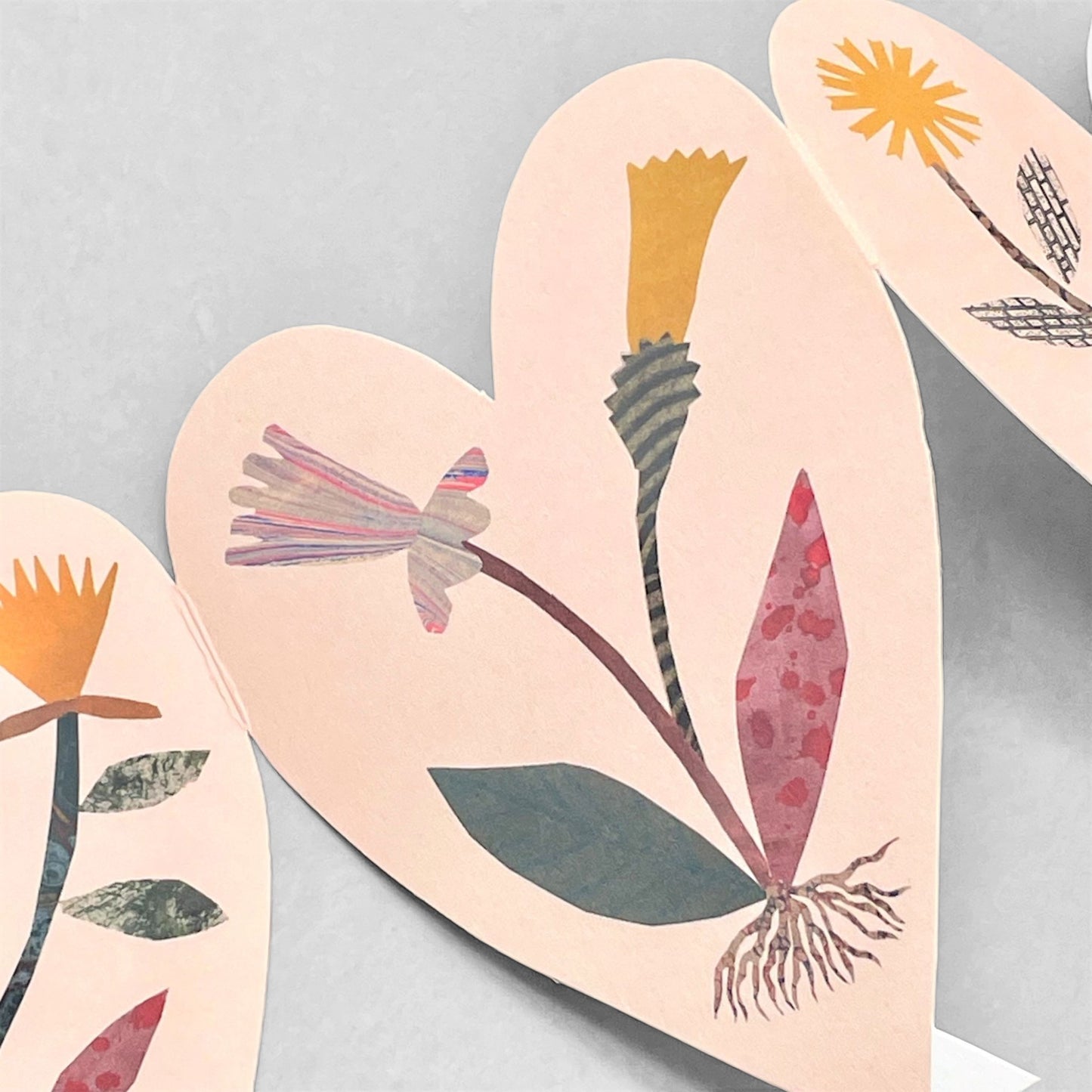 a concertina greetings card of six pink hearts with collage of wild flowers, by Hadley Paper Goods