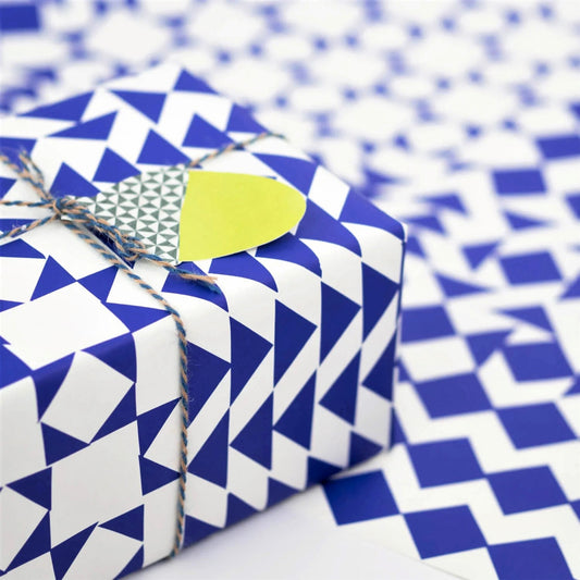 blue and white geometric wrapping paper by Hadley Paper Goods, shown as a present