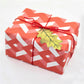 red and pink diamond design gift wrap by Hadley Paper Goods, wrapped as a present