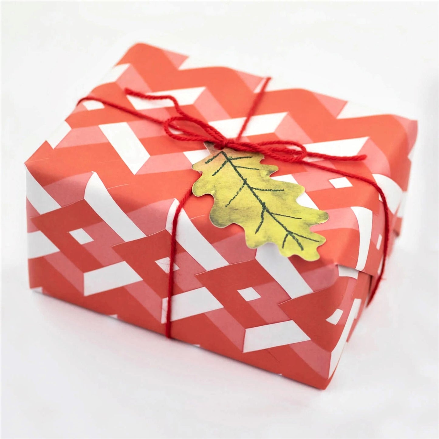 red and pink diamond design gift wrap by Hadley Paper Goods, wrapped as a present
