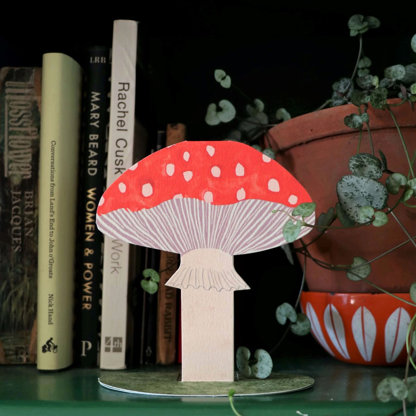 red toadstool stand-up greetings card by Hadley Paper Goods, displayed on a shelf