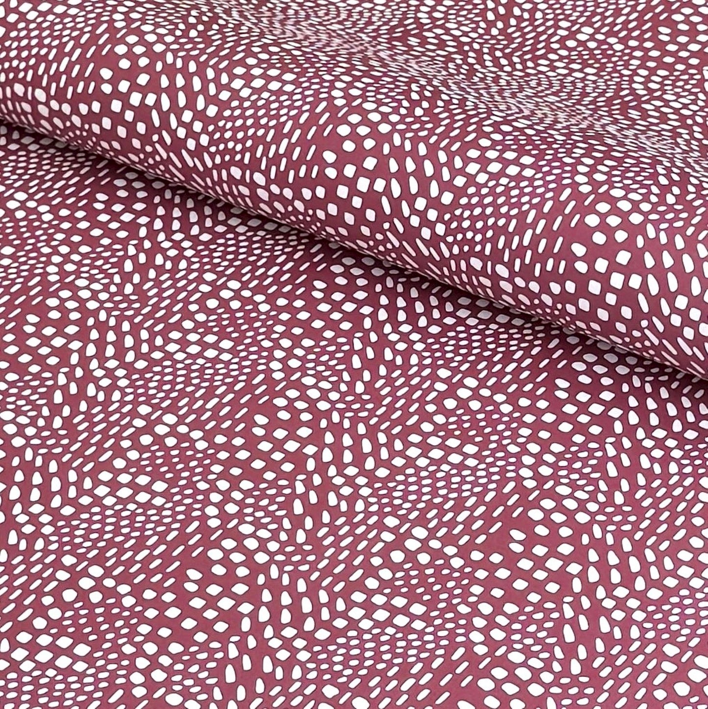 a sheet of wrapping paper in aubergine with a white abstract pattern