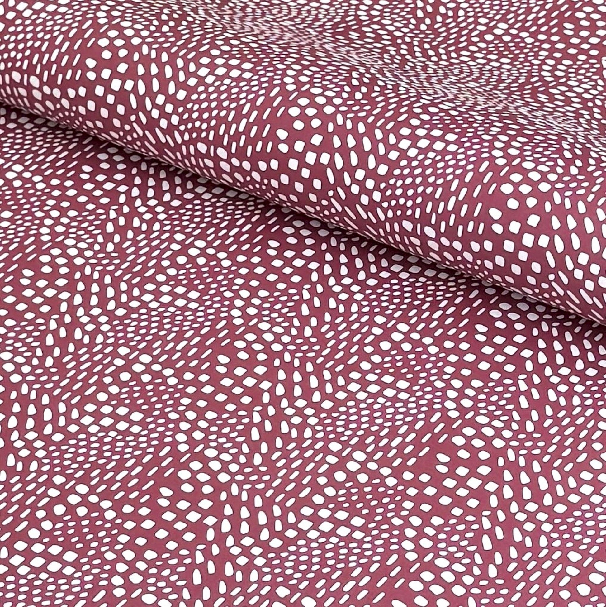 a sheet of wrapping paper in aubergine with a white abstract pattern