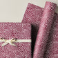 a sheet of wrapping paper in aubergine with a white abstract pattern