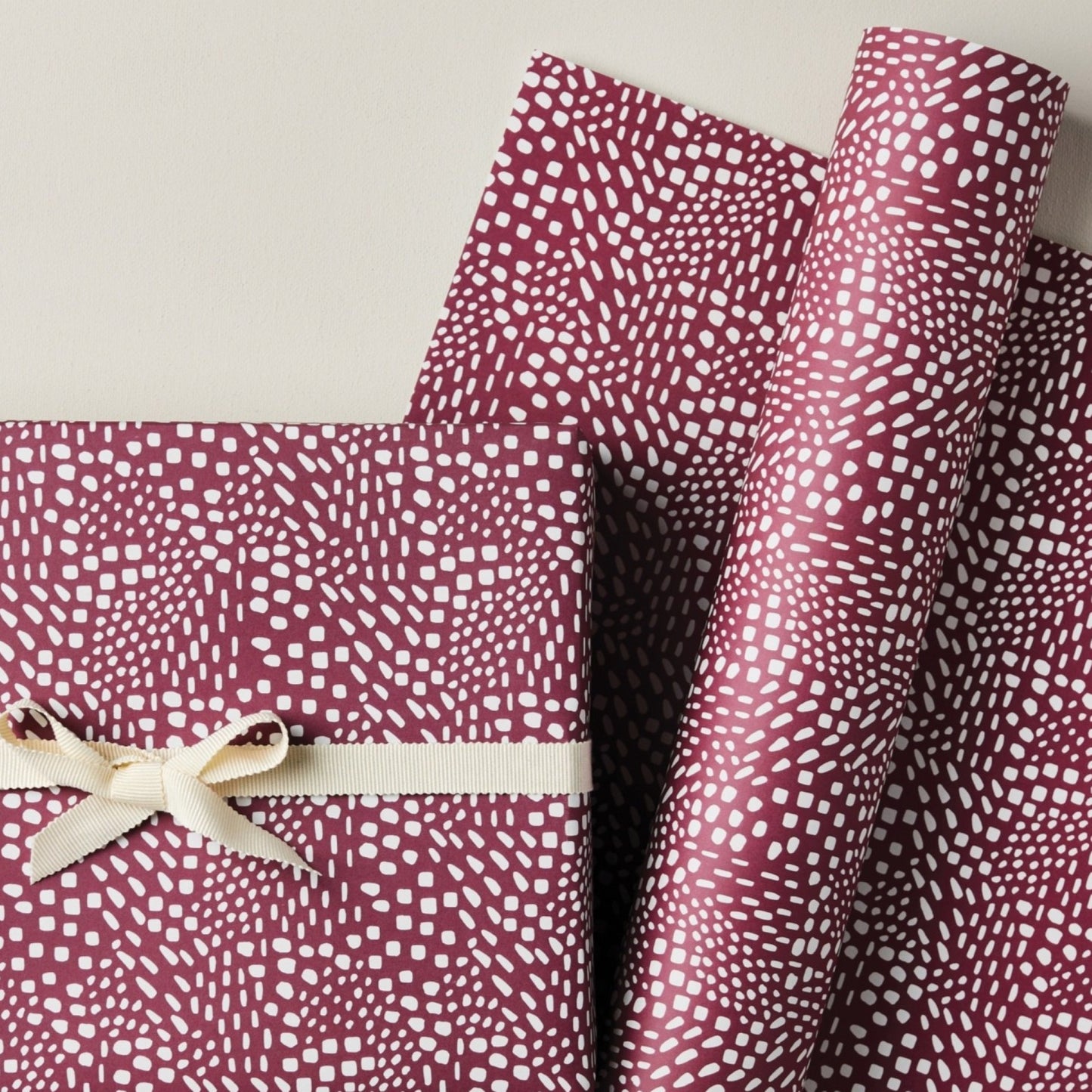 a sheet of wrapping paper in aubergine with a white abstract pattern