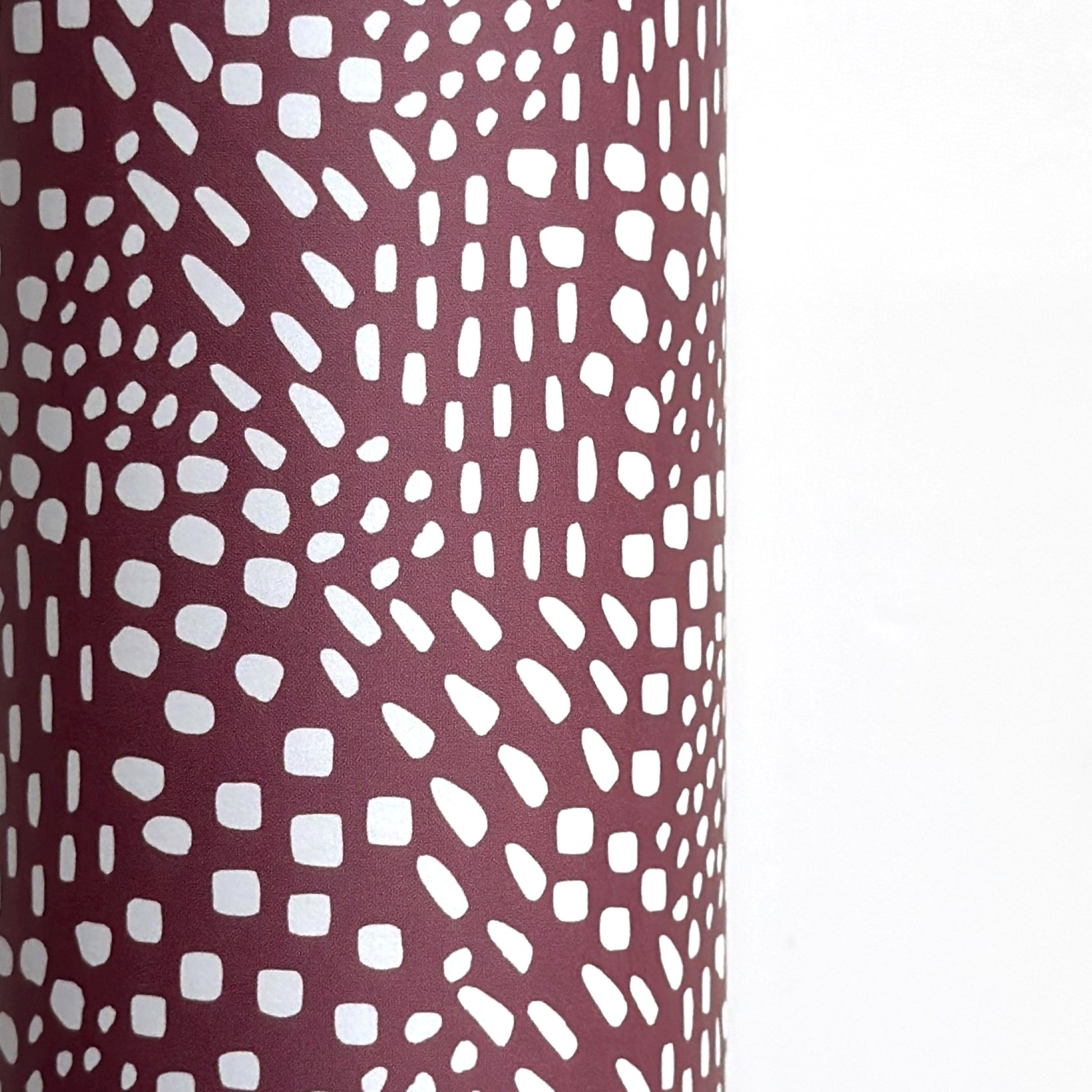 a sheet of wrapping paper in aubergine with a white abstract pattern