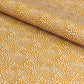 a sheet of wrapping paper in mustard with a small abstract pattern in white