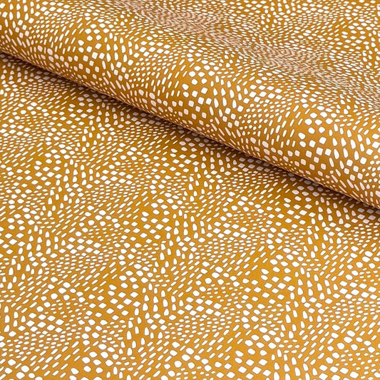 a sheet of wrapping paper in mustard with a small abstract pattern in white