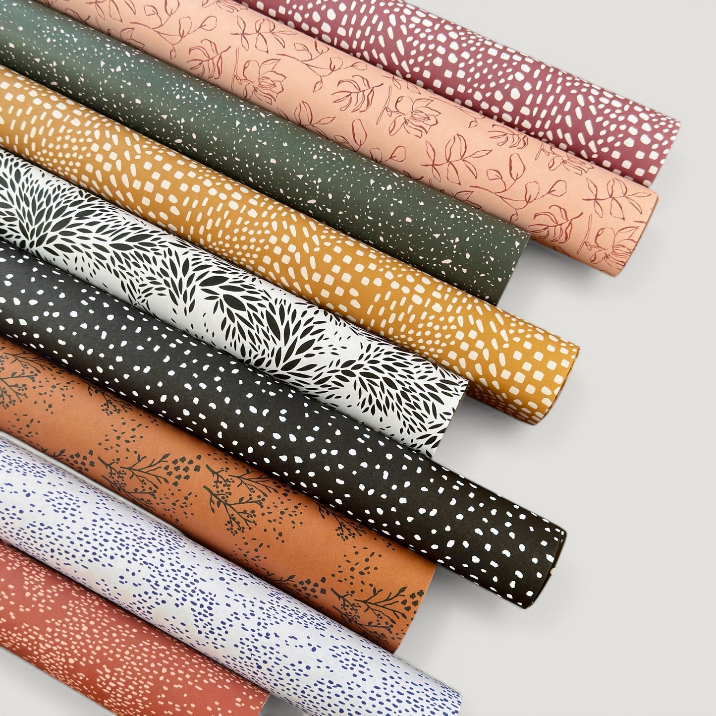 rolls of wrapping paper by Ink & Bloom with abstract patterns.  