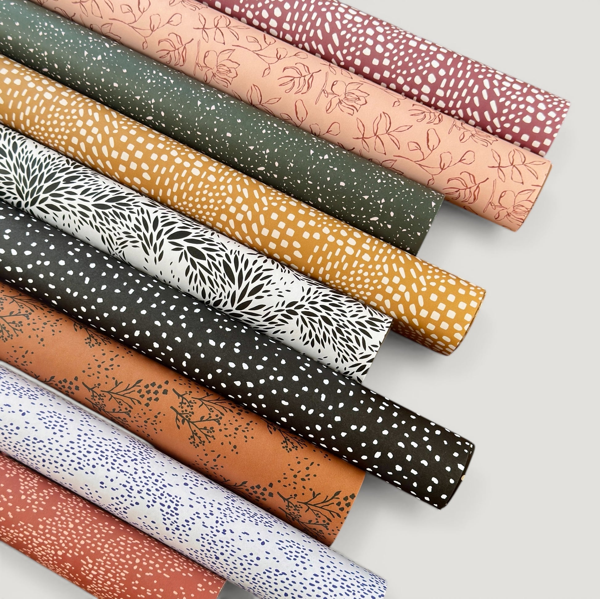 rolls of wrapping paper by Ink & Bloom with abstract patterns.  