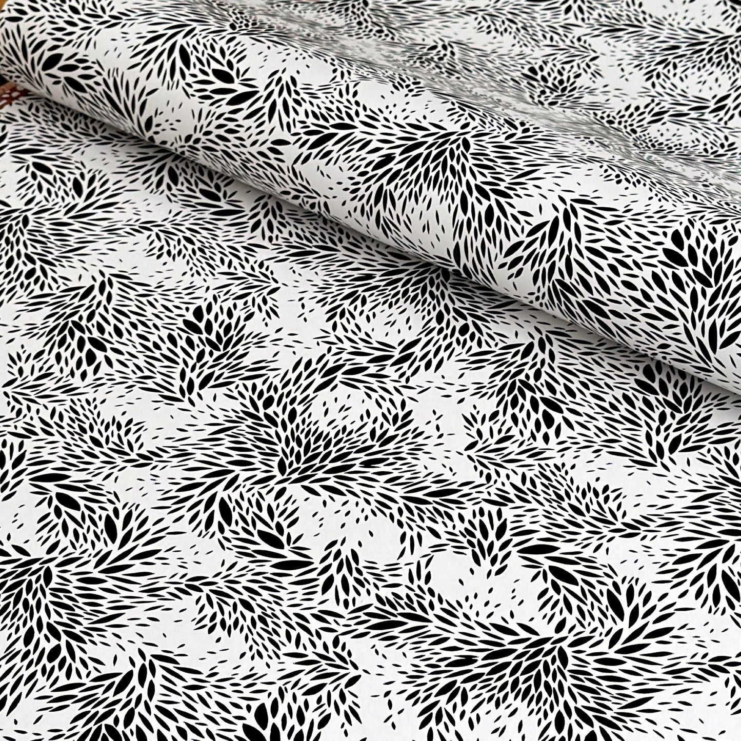 a sheet of wrapping paper with a black floral design on white