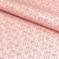 a sheet of wrapping paper in blush pink with a floral sketched pattern in brown