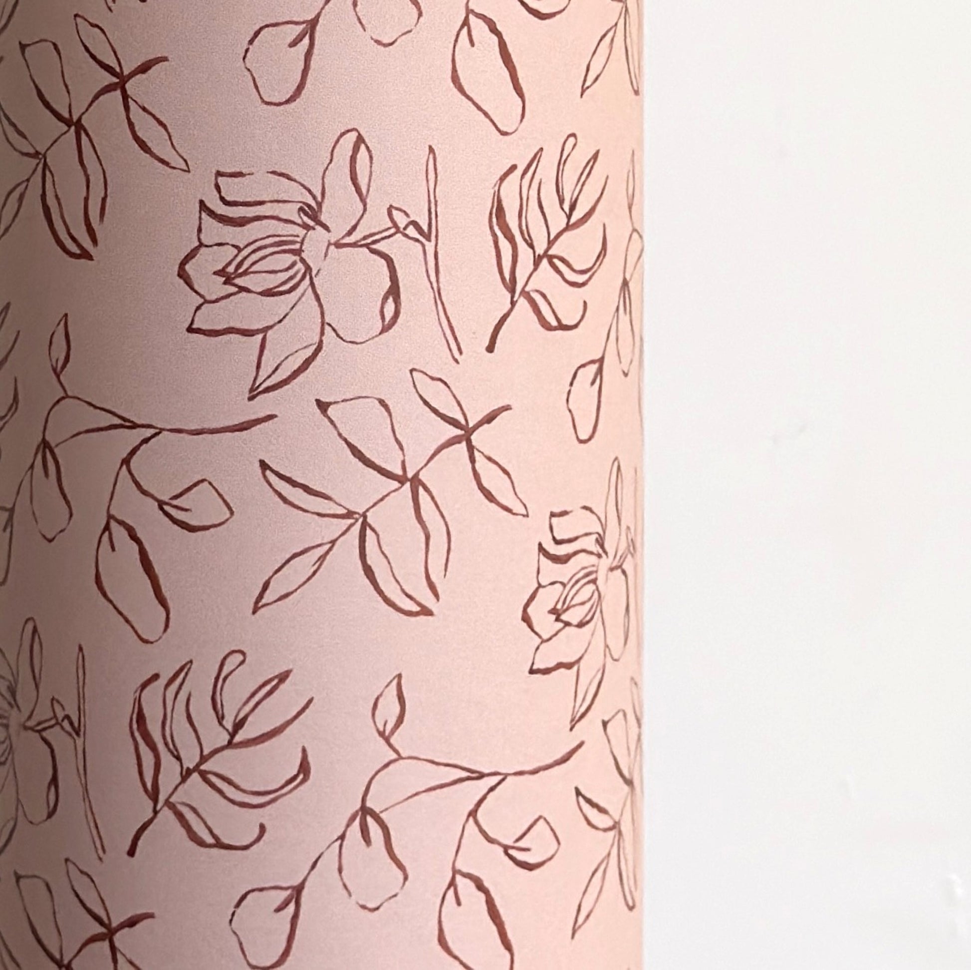 a sheet of wrapping paper in blush pink with a floral sketched pattern in brown