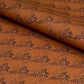a sheet of brown wrapping paper with an abstract floral pattern in black