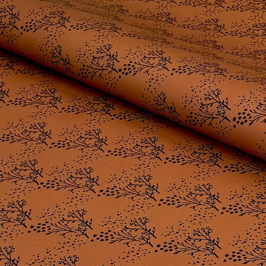 a sheet of brown wrapping paper with an abstract floral pattern in black