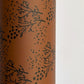 a sheet of brown wrapping paper with an abstract floral pattern in black