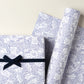 a sheet of wrapping paper in white with a blue speckle design