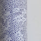 a sheet of wrapping paper in white with a blue speckle design