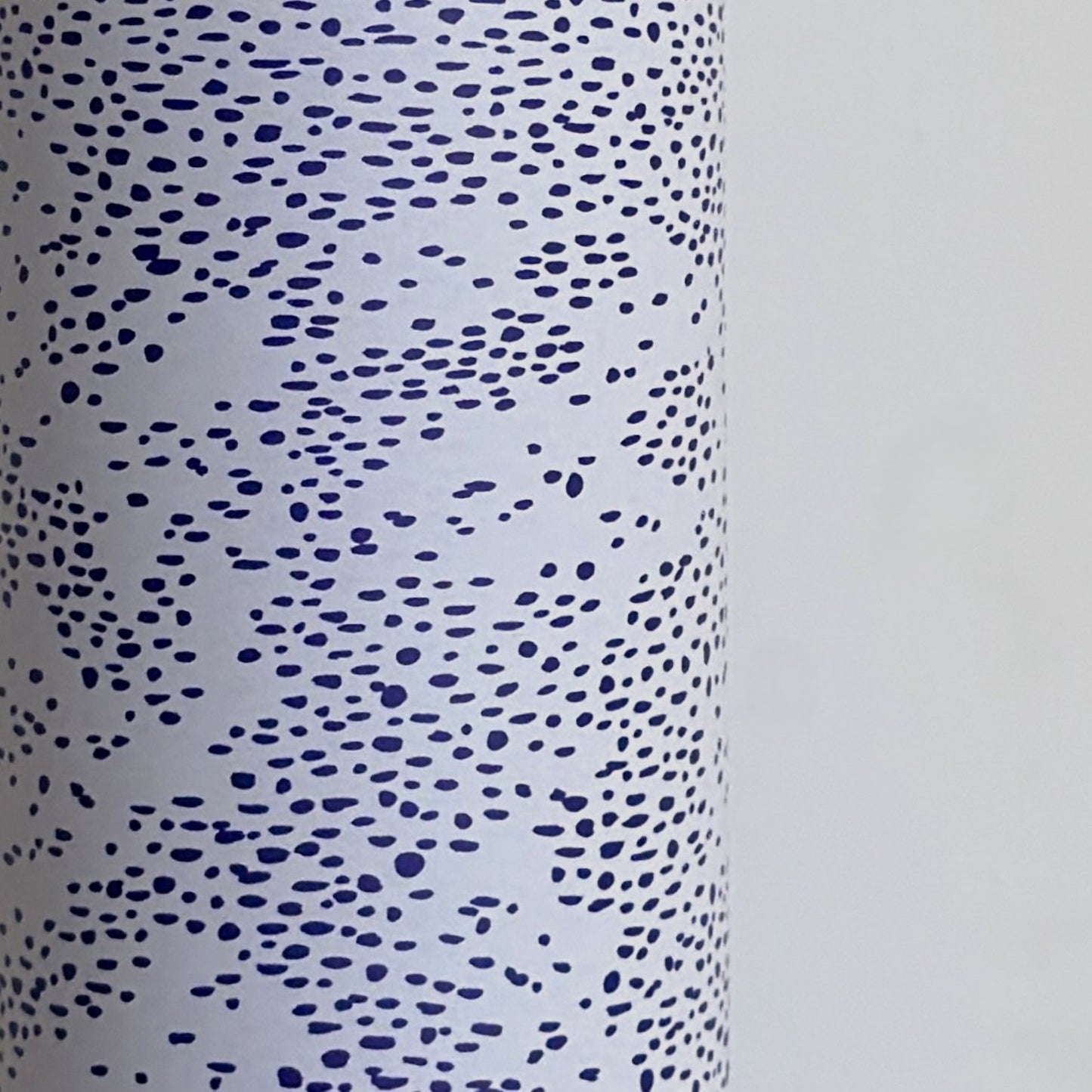 a sheet of wrapping paper in white with a blue speckle design