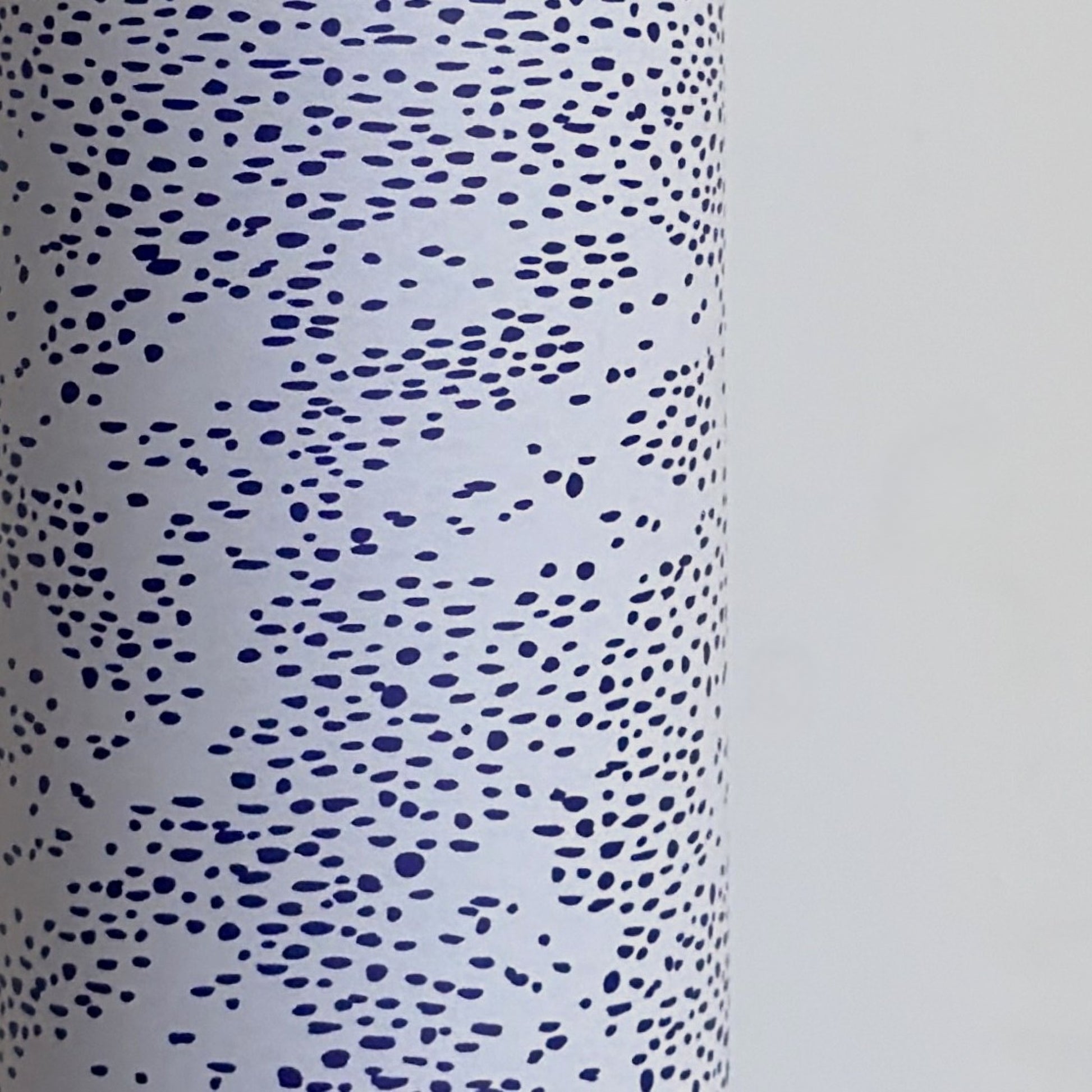a sheet of wrapping paper in white with a blue speckle design