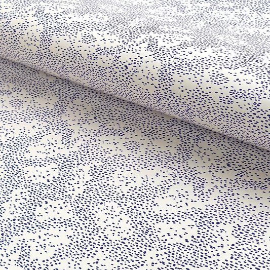 a sheet of wrapping paper in white with a blue speckle design