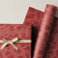 a sheet of wrapping paper in rust with an abstract pink speckled design