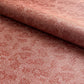 a sheet of wrapping paper in rust with an abstract pink speckled design