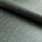 a sheet of wrapping paper in dark green with a speckle design in white