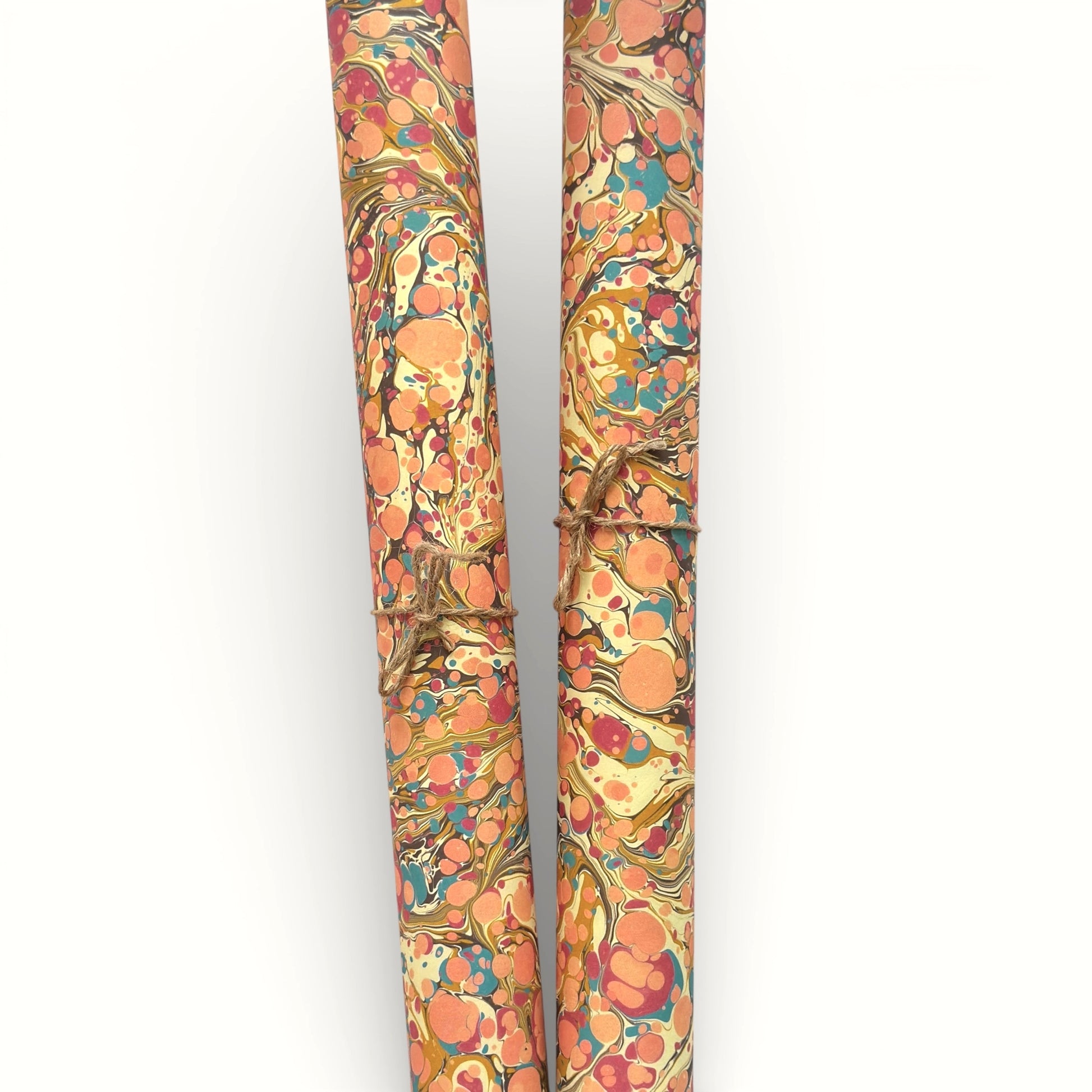 printed marbled wrapping paper by Jemma Lewis with a marbled pattern in blush pink, mustard, pale blue, brown and raspberry. Rolled