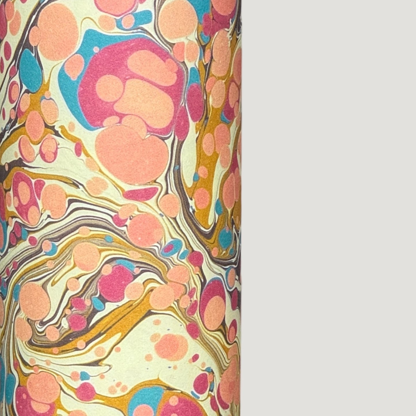 printed marbled wrapping paper by Jemma Lewis with a marbled pattern in blush pink, mustard, pale blue, brown and raspberry. close up