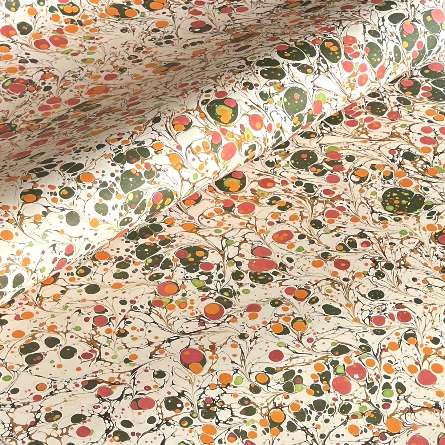 Printed marbled wrapping paper by Jemma Lewis Marbling. Marbled paper in bright yellow, pink and green on white backdrop.