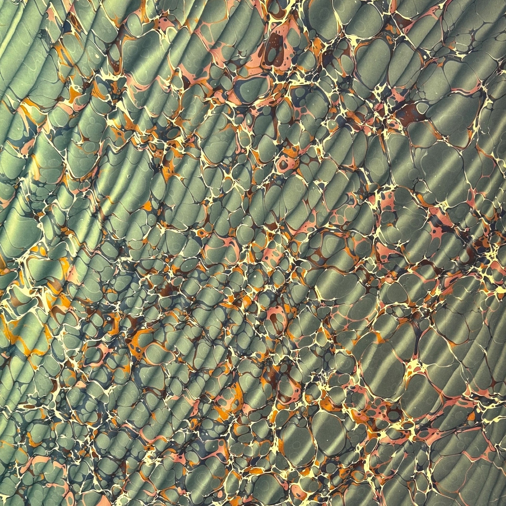 sheet of printed marbled wrapping paper by Jemma Lewis, ripple effect in teal green, ochre and pink