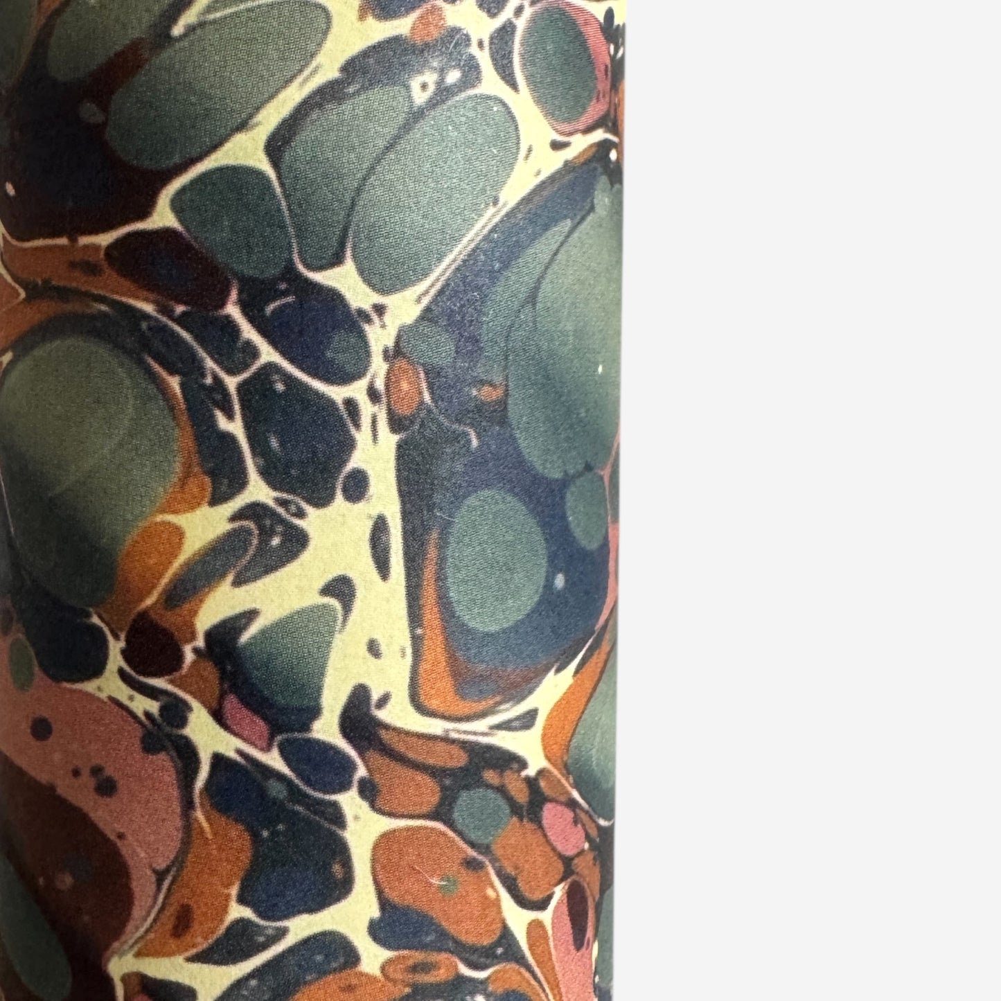 sheet of printed marbled wrapping paper by Jemma Lewis, ripple effect in teal green, ochre and pink. Close up