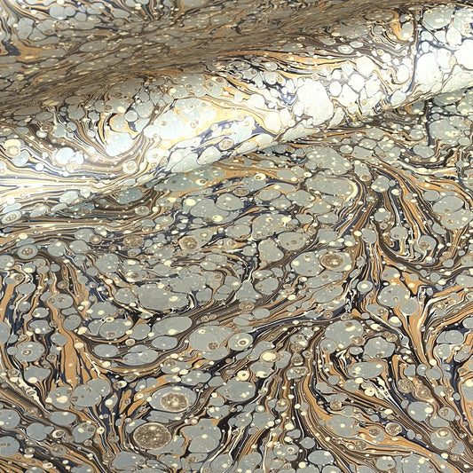Printed marbled wrapping paper by Jemma Lewis Marbling. Marbled paper in earth tones of brown, sand, grey and soft blue.